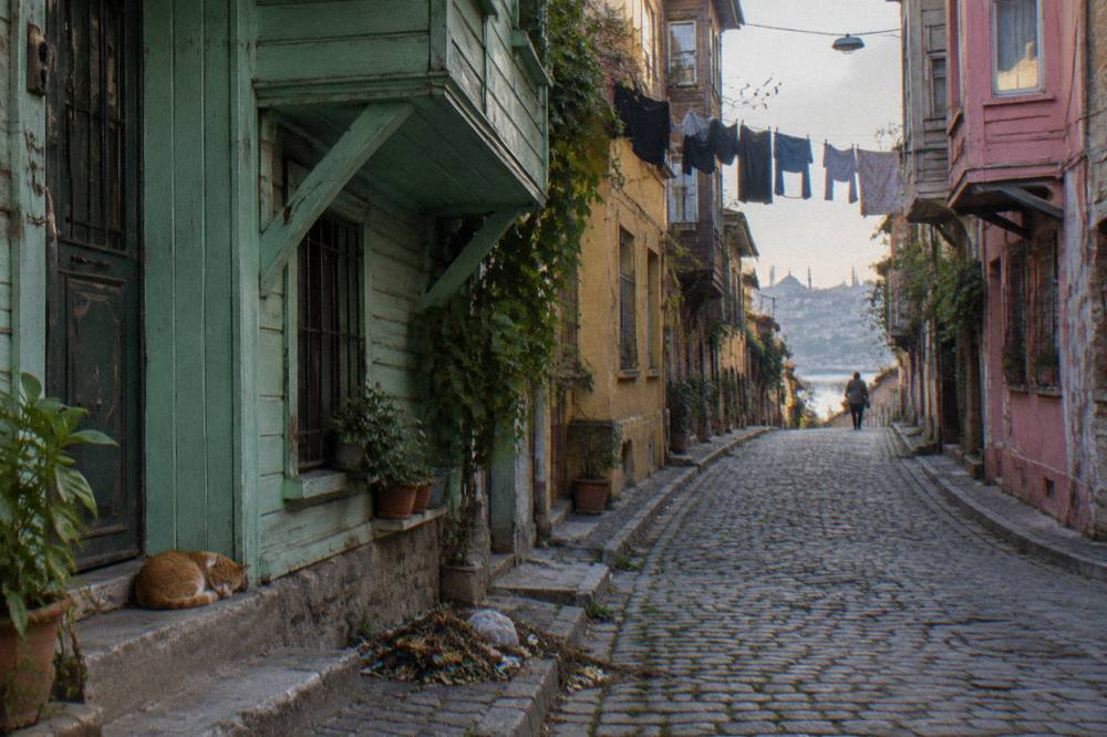 Narrow cobblestone street in Balat with colourful houses in soft morning light