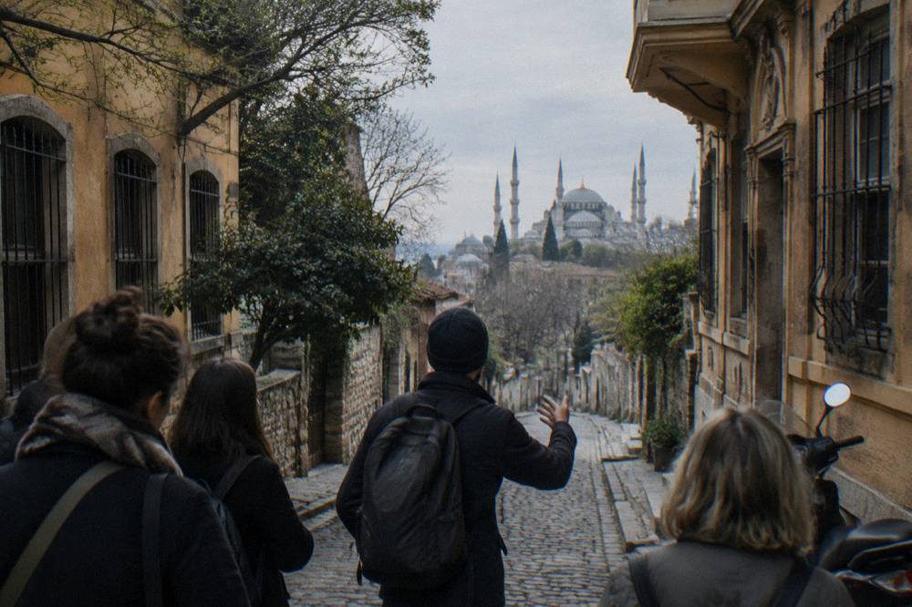 A tour guide speaking to a small group on a cobblestone street in the Sultanahmet area