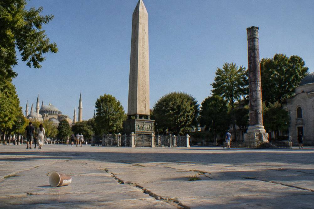 A stone plaza in Istanbul's old city with an obelisk and historic columns in late afternoon light