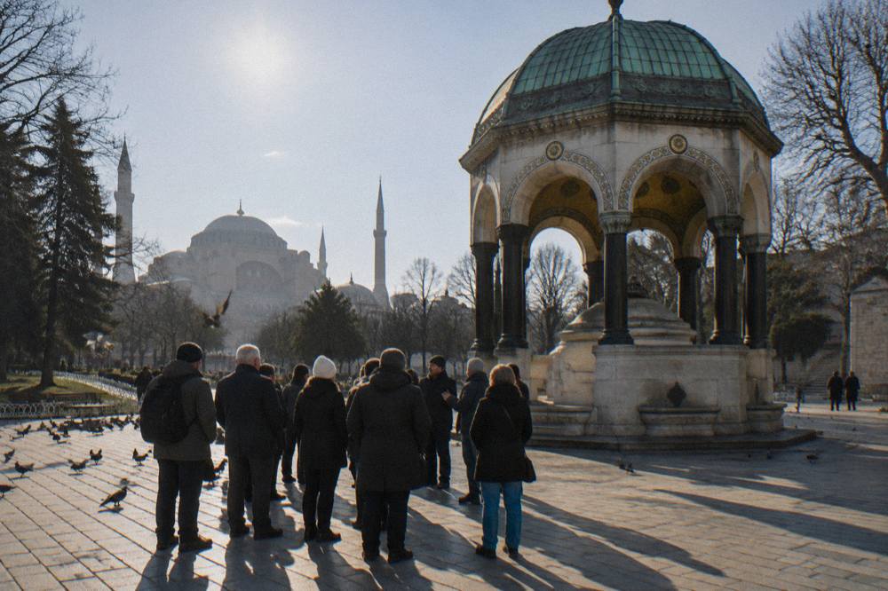 A walking tour group gathered around a guide near the German Fountain in Sultanahmet square