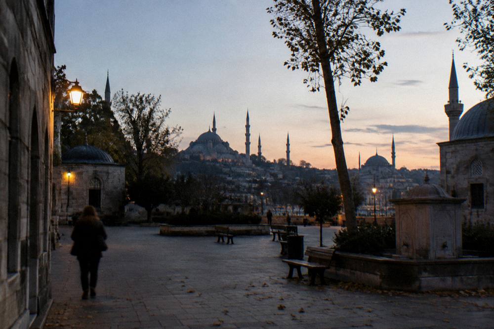 A wide plaza in Istanbul at dusk with historic domes on the horizon