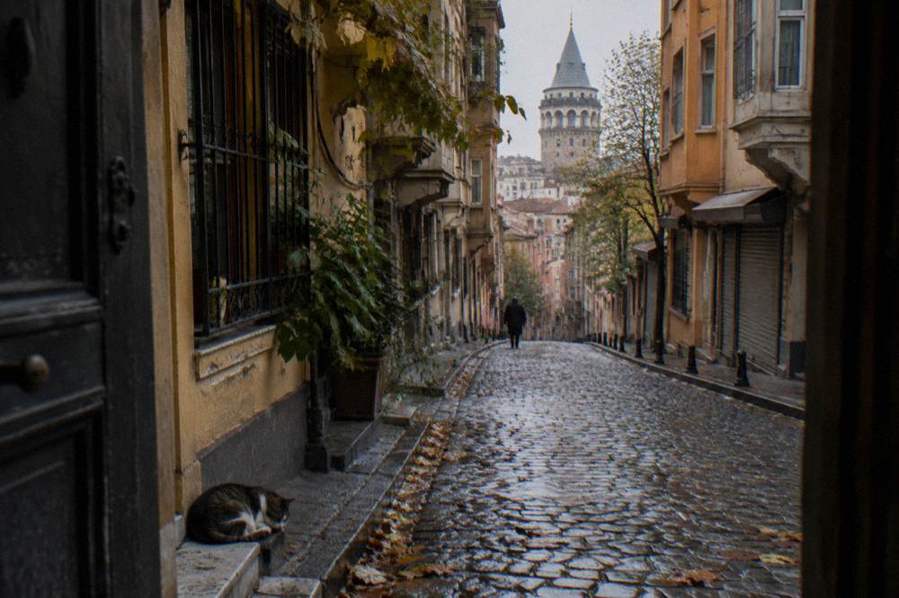 Narrow cobbled lane in Galata lined with old apartment buildings and small shops
