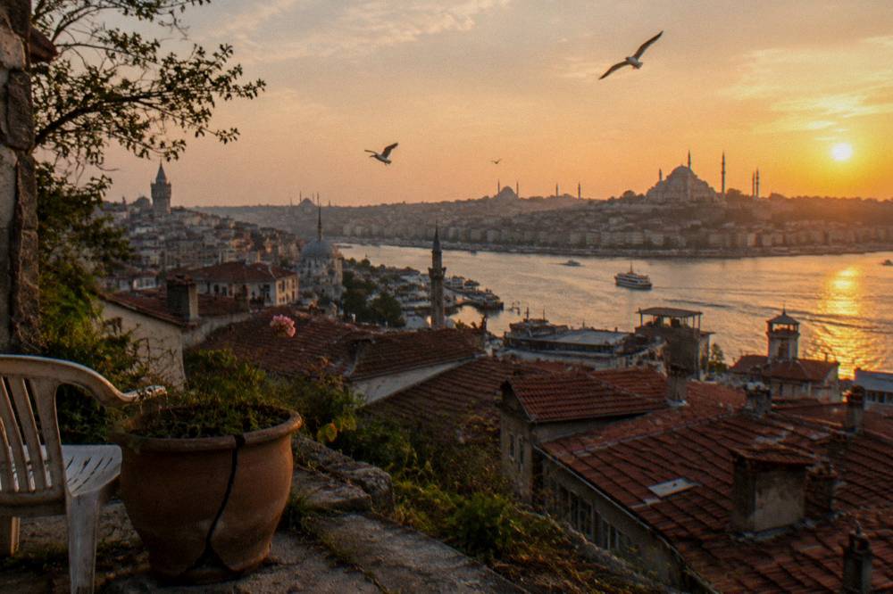 Panorama of Istanbul skyline and Golden Horn seen from a hillside terrace above rooftops