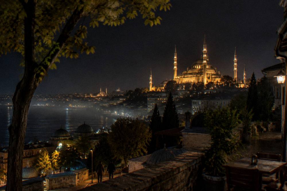 Suleymaniye Mosque domes and minarets lit up against a dark sky