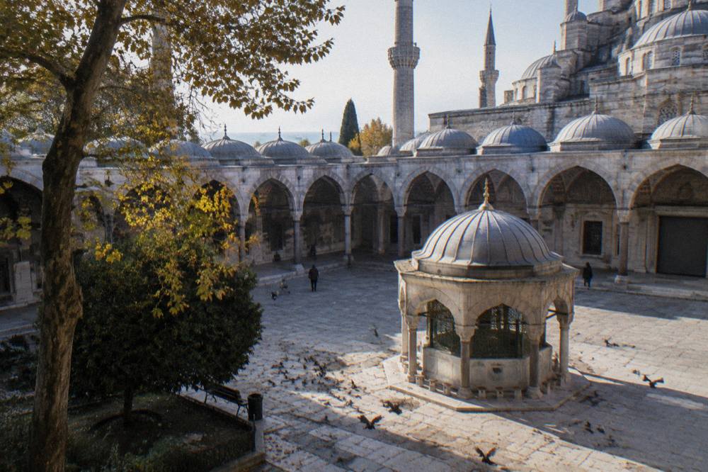Courtyard of the Blue Mosque with its fountain and arched colonnade under a clear sky