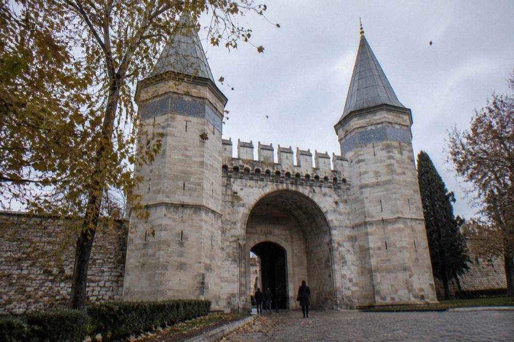Stone gate with twin octagonal towers and tiled roof marking the entrance to the palace's inner courts
